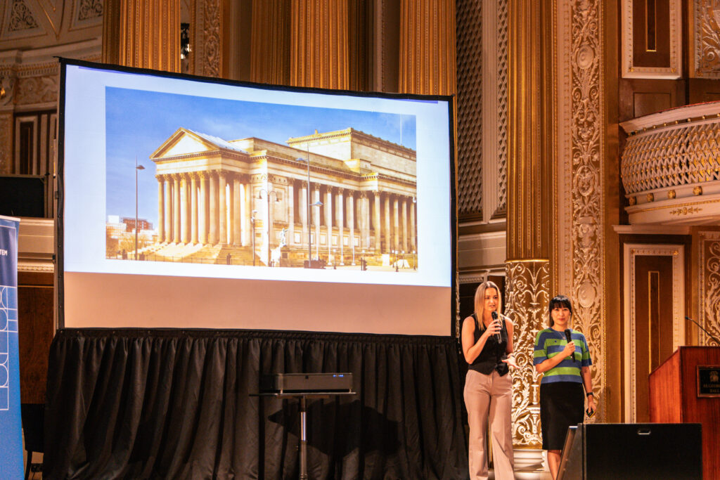 Kelly Lee, Delivery Manager and Trang Erskine, Product Manager introduce Design System Day 2024 on stage at St.George's Hall in Liverpool.