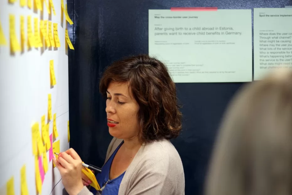 Vicky Teinaki Writes on na post-it as part of a UX design session